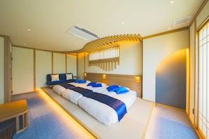 A hotel room with a large bed, a desk, and a wall-mounted air conditioning unit. - Hotel O. Naruto (Naruto)