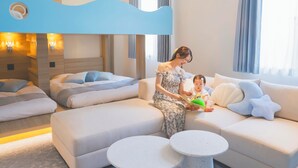 A modern hotel room with a bunk bed, a sofa, a reading area, and a small round table. - Hotel O. Naruto (Naruto)