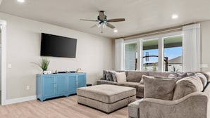 A living room with a sectional sofa, a blue cabinet, and a ceiling fan. - Spacious 3BR Home + Office | Work & Relax (Boardman)