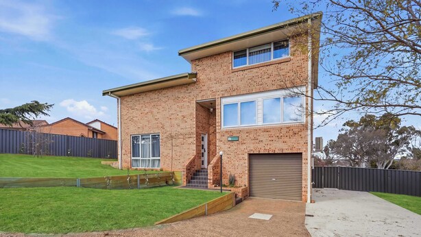 A two-story brick house with a front garage, a well-maintained lawn, and a fenced backyard. - Linton, Architect Home Near Mt Panorama (Kelso)