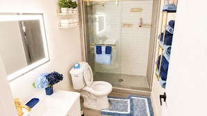 Ein modernes Badezimmer mit Duschkabine aus Glas, Toilette und Waschbecken mit Spiegel.