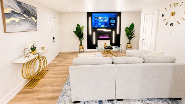 Ein modernes Wohnzimmer mit einer Couch, einem Fernseher und einem Kamin.