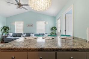 A kitchen with a granite countertop, a ceiling fan, and a dining area with a table and chairs. - So Cute! WALK to Beach Close to Restaurants Marina & State Park Fenced 4 Ur Dog! (Panama City Beach)