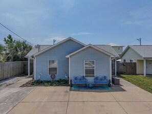 A residential house with a front porch, a small garden, and a wooden fence. - So Cute! WALK to Beach Close to Restaurants Marina & State Park Fenced 4 Ur Dog! (Panama City Beach)