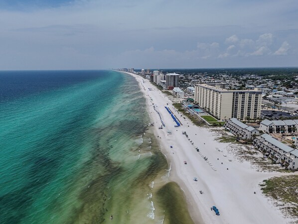 A coastal cityscape with a beach, hotels, and a clear sky. - So Cute! WALK to Beach Close to Restaurants Marina & State Park Fenced 4 Ur Dog! (Panama City Beach)