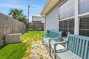 A backyard with a wooden fence, a bench, and a house with a window. - So Cute! WALK to Beach Close to Restaurants Marina & State Park Fenced 4 Ur Dog! (Panama City Beach)