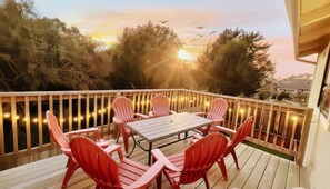 Una terraza con una mesa y sillas, rodeada por una barandilla de madera.