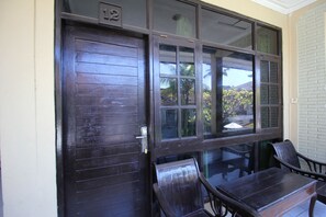 A dark wooden door with a glass panel and a number '12' above it. - Moanna Stay Kuta Beach (Kuta)