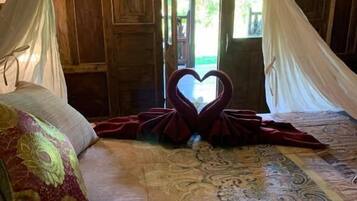 Un lit à baldaquin, une décoration en forme de cœur et une couvre-lit à motifs.
