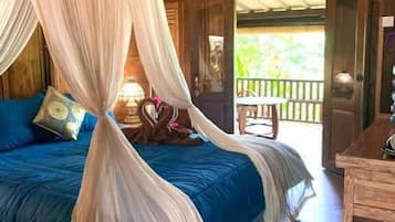 Une chambre avec un lit, une table en bois et un balcon doté d’une balustrade.