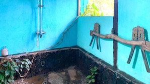 Un baño con pared azul, ducha y lavabo de piedra.