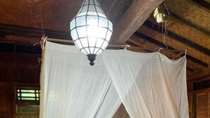 Una cama con dosel y un adorno con forma de corazón en las almohadas.