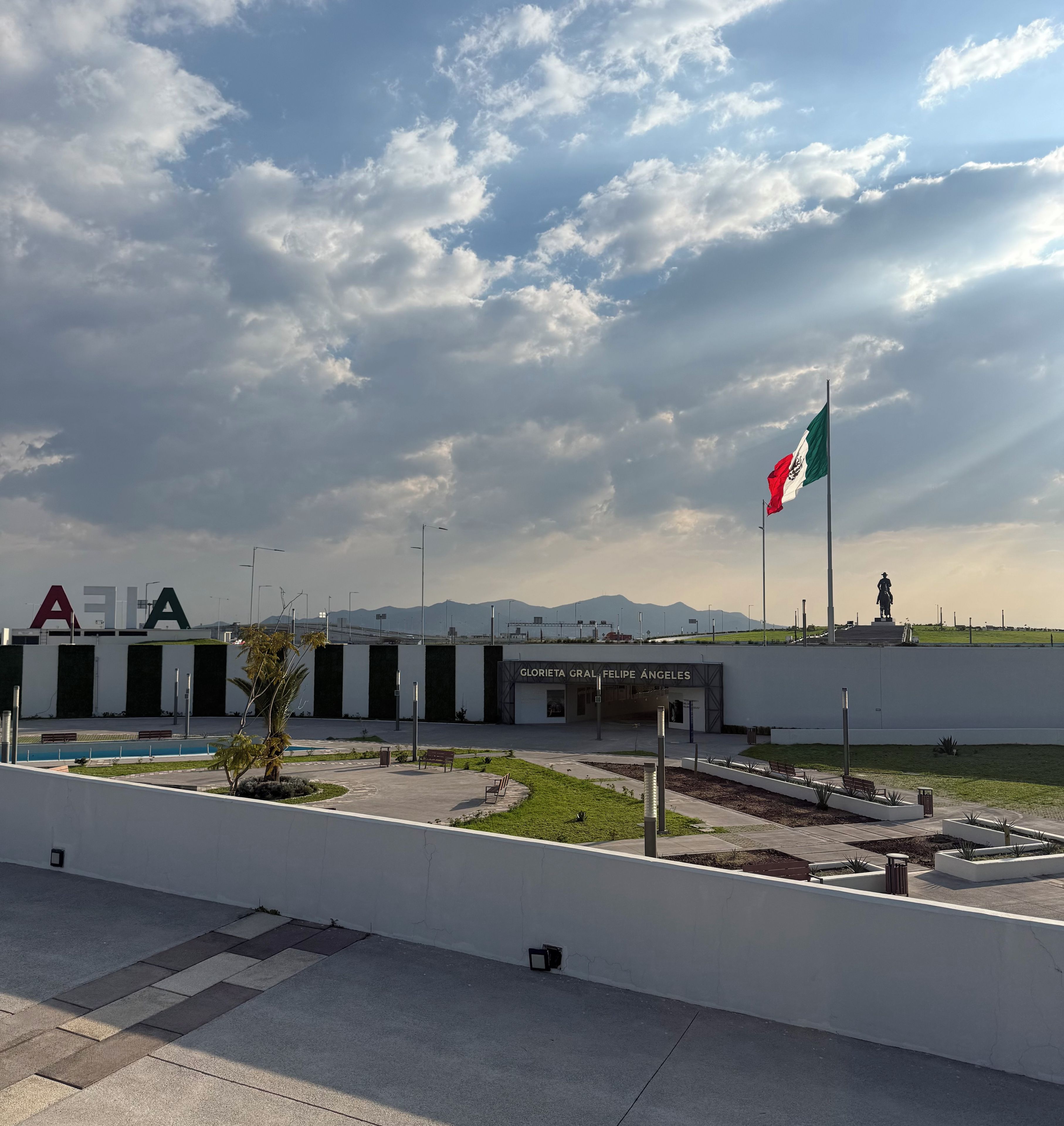 Un edificio con una bandera, una estatua y un letrero que dice 'GLORIANT GLORIA FELIPE ÁÑELES'.