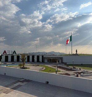 A building with a flag, a statue, and a sign reading 'GLORIANT GLORIA FELIPE ÁÑELES'.