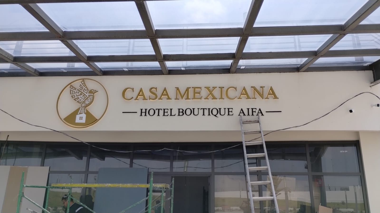 Een hotelschilt met de naam 'CASA MEXICANA HOTEL BOUTIQUE AIFA' en een logo.