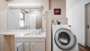 Un bagno moderno con lavatrice integrata, uno specchio grande e un water.