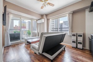 A modern living room with a sofa, a small table, and a ceiling fan. - TetiTeti (Sapporo)
