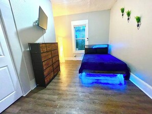 A bedroom with a bed, dresser, and a window. - Comfy 3/1 With Everything You Need - 5 Mins to DT (Jacksonville)