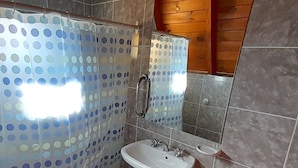 Un bany amb dutxa, un lavabo i un mirall.