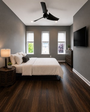 A bedroom with a bed, a ceiling fan, a TV, and a window. - A modern artsy 3 bedroom/3.5 bathroom townhome in Baltimore AKA Charm City (Baltimore)