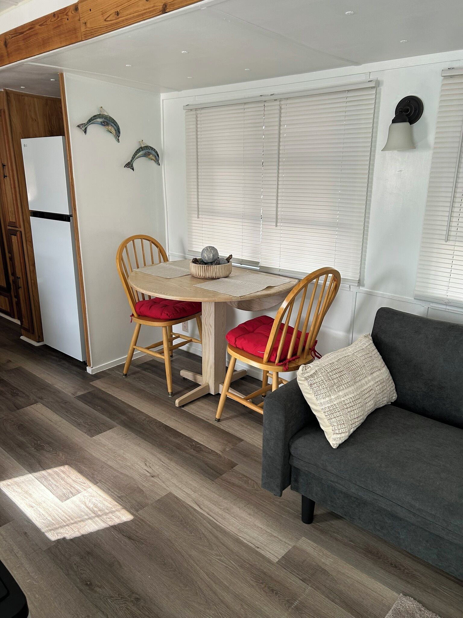 Un espacio habitable compacto con comedor, sofá y refrigerador.
