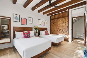 A hotel room with two beds, wooden headboards, a large mirror, and a decorative wooden panel. - "Gran Flamenco" @BlueDeerTulum - 4 Bed+4.5 Bath LUX Villa - Pool, Jacuzzi, Staff (Tulum)