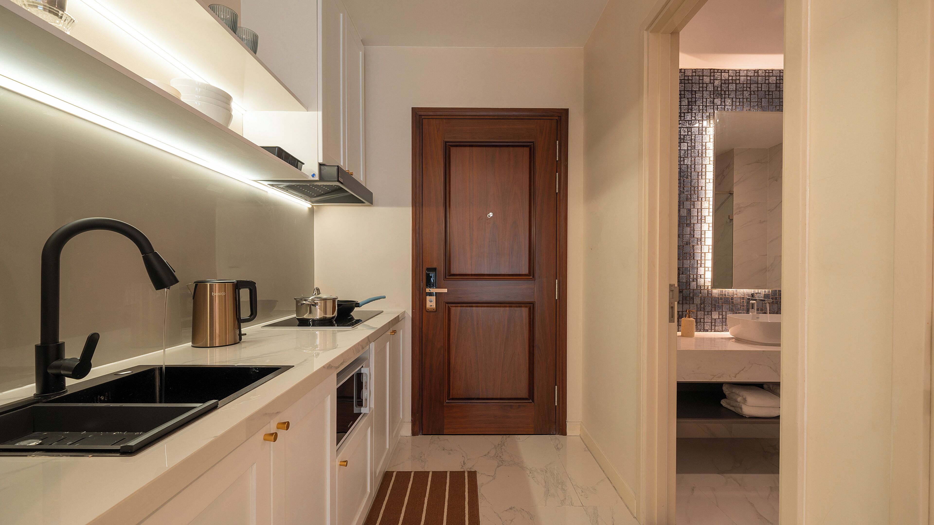 A modern kitchen with a built-in stove, a coffee maker, and a sink.