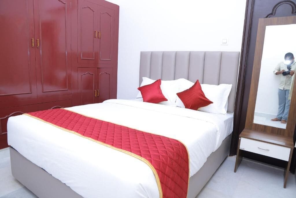 Una habitación de hotel con cama, armario y espejo.