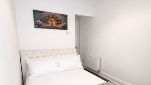 Ein Schlafzimmer mit einem Bett, einem Heizkörper und einem Gemälde an der Wand.