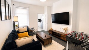 Ein modernes Wohnzimmer mit einer Couch, einem Couchtisch und einem Kicker.