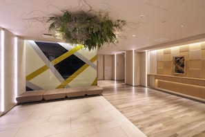 A modern interior with a reception desk, a seating area, and a decorative ceiling installation. - KOUSA Osaka Namba (Osaka)