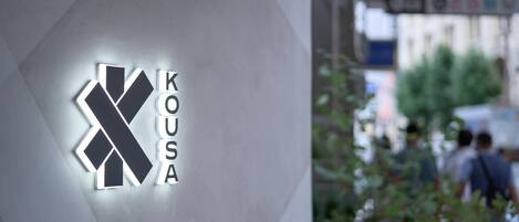 A building with a geometric logo and the name 'KOUASA' on the facade.