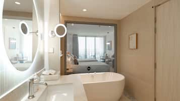 A modern bathroom with a freestanding bathtub, a large mirror, and a vanity with a sink.