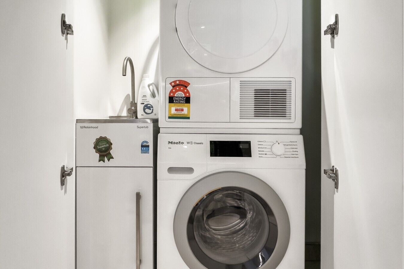 A compact washer and dryer unit with a visible energy rating sticker, a control panel, and a water inlet.