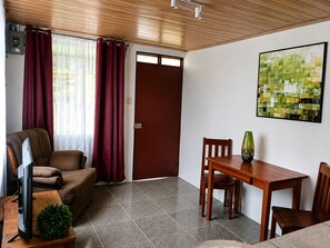 Un salon avec un canapé, un téléviseur et une table à manger avec des chaises.