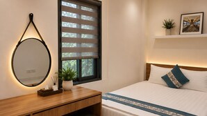 Un dormitorio moderno con cama, mesita de noche, espejo y ventana con persianas.
