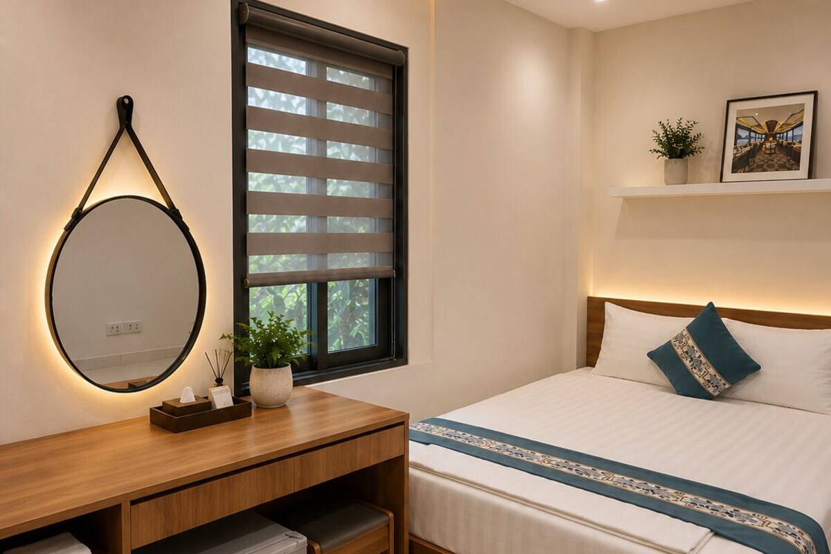 Ein modernes Schlafzimmer mit Bett, Nachttisch, Spiegel und einem Fenster mit Jalousien.