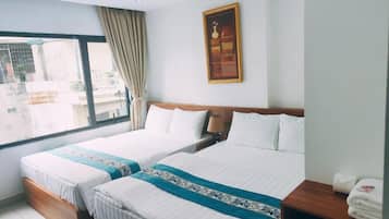 Una habitación de hotel con dos camas, un ventanal grande y un cuadro en la pared.