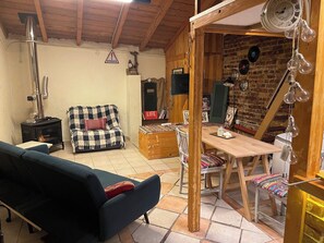A cozy room with a wooden ceiling, a sofa, a table with chairs, and a fireplace. - Cozy Kerkyra Studio with Extra Beds (Kerkira)