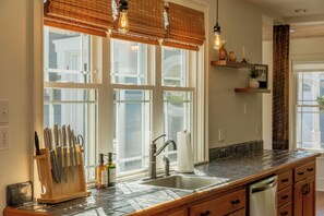 A kitchen with a large window, a sink, and a knife block. - 'Riverbend Retreat' River Access! Hot Tub! Large Game Room! Kayaks! Pickle Ball! (Newport)