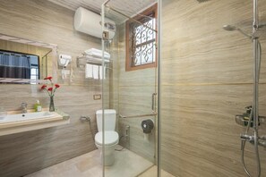 A bathroom with a glass-enclosed shower, a toilet, a sink with a mirror, and a window with decorative bars. - Sapa Fansipan View House (Sa Pa)