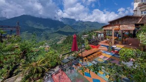 A restaurant with outdoor seating overlooking a mountainous landscape. - Sapa Fansipan View House (Sa Pa)