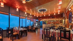 A restaurant with wooden floors, tables with patterned tablecloths, and hanging lanterns. - Sapa Fansipan View House (Sa Pa)