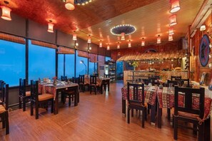 A restaurant with wooden floors, tables with patterned tablecloths, and hanging lanterns. - Sapa Fansipan View House (Sa Pa)