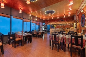 Un restaurante con suelos de madera, mesas con manteles estampados y faroles colgantes.