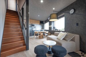 Un interior moderno con escalera, cocina, comedor y zona de estar.