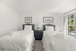 A hotel room with two beds, a nightstand with a lamp, and two framed pictures on the wall. - Georgetown’s Secret Garden in the West Village, Steps from the University (Washington)