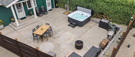 Un jardin avec un jacuzzi, un coin salon et une table de patio.