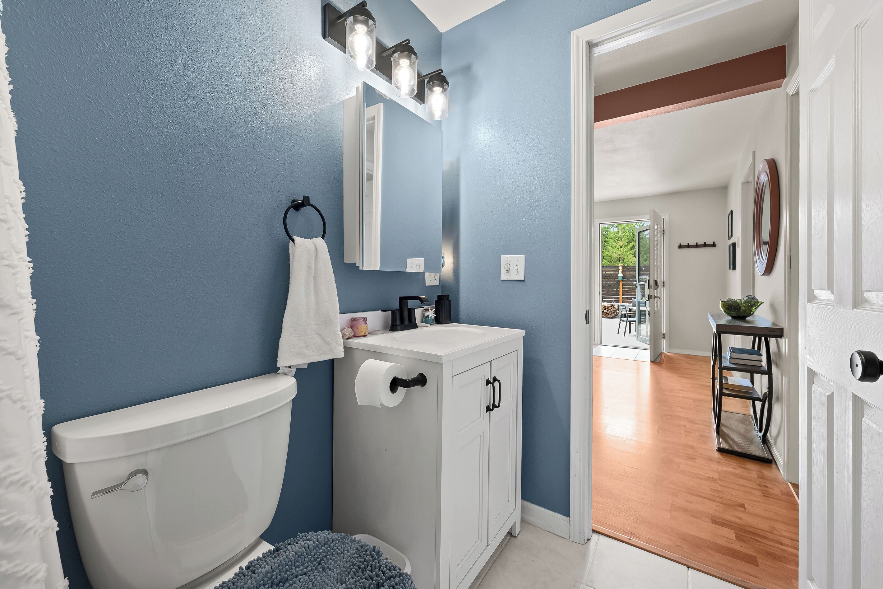A bathroom with a toilet, sink, and towel rack.