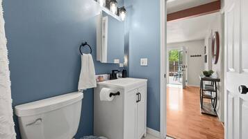A bathroom with a toilet, sink, and towel rack.